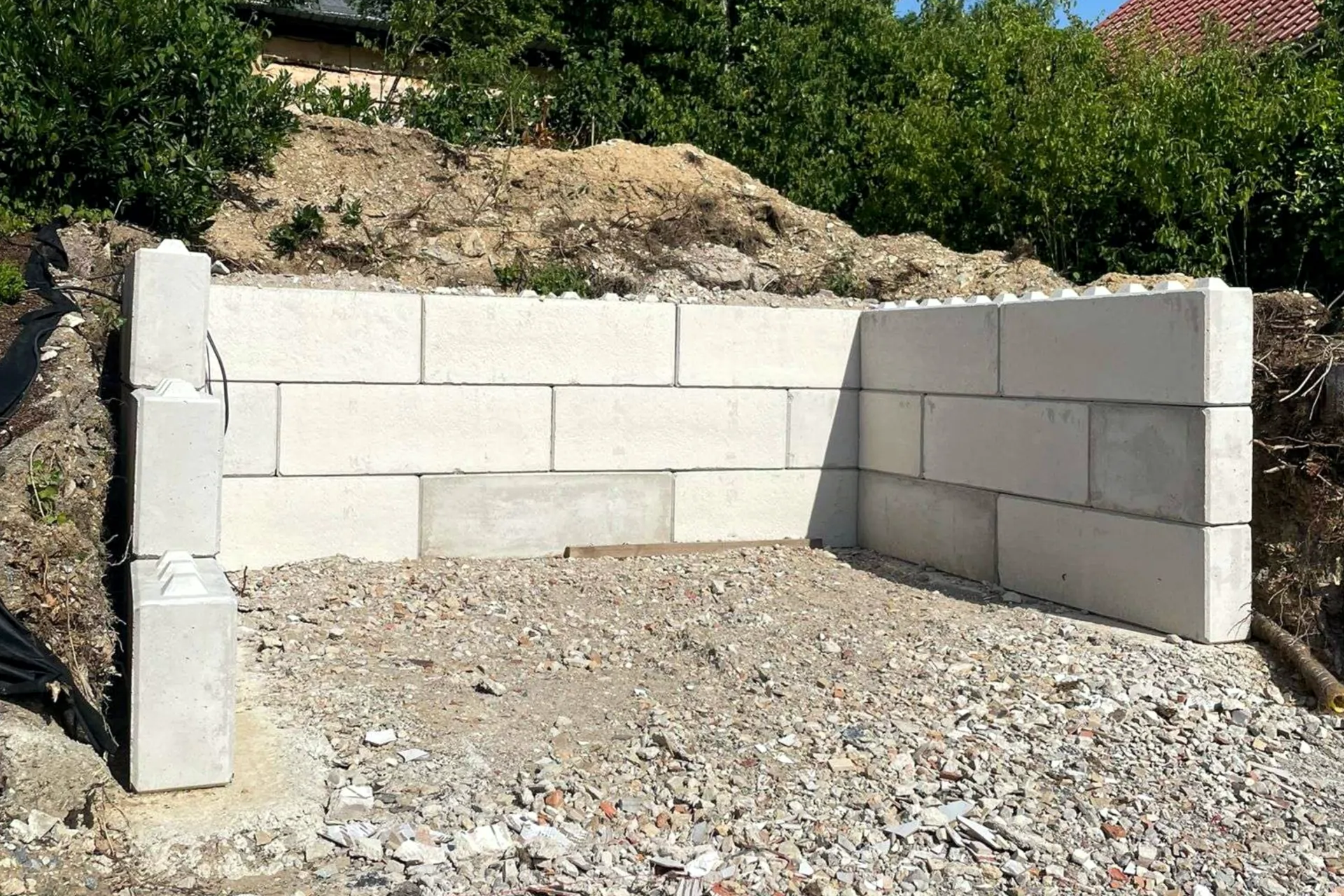 Betonblöcke stützen Böschung und Parkfläche ab