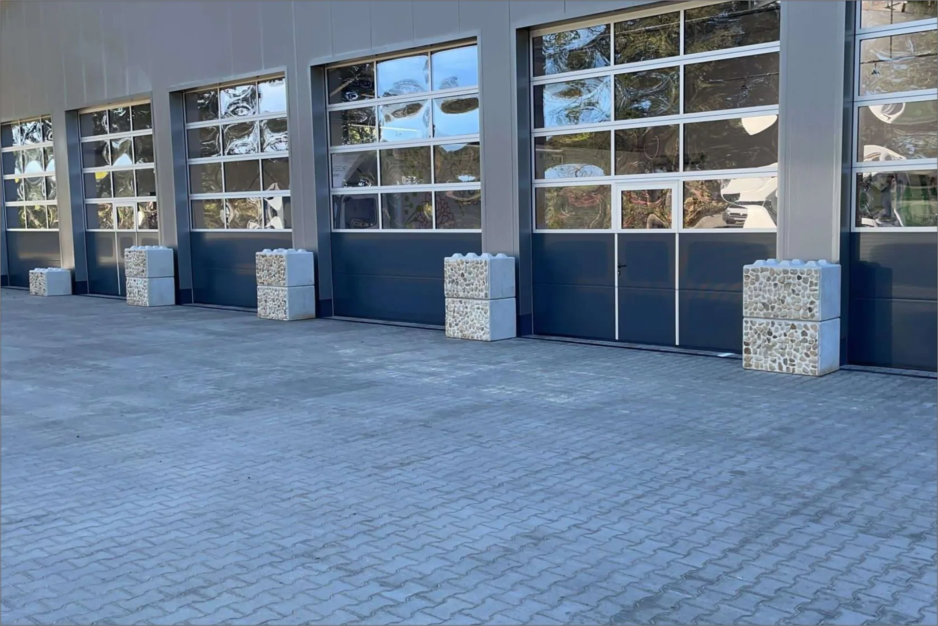Betonblöcke als Schutzbarriere vor einer Halleneinfahrt